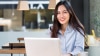 Young woman smiles in front of her computer while checking IELTS exam dates in Colombia