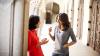 Dos mujeres conversan en el pasillo de una universidad