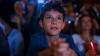 Un niño mira una película en cine.
